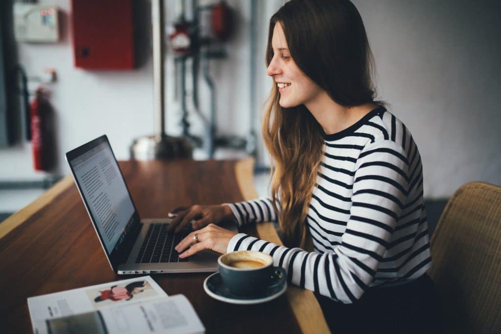 Lady working on laptop drinking coffee